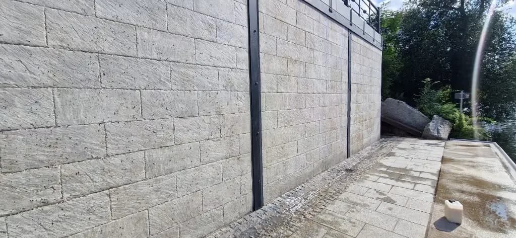 Mur z bloczków po usunięciu graffiti — czysty kamień i odświeżona nawierzchnia